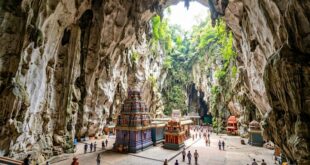 Огромный зал Temple Cave с просветом к небу, сине-фиолетовая башня святилища и маленькие храмы
